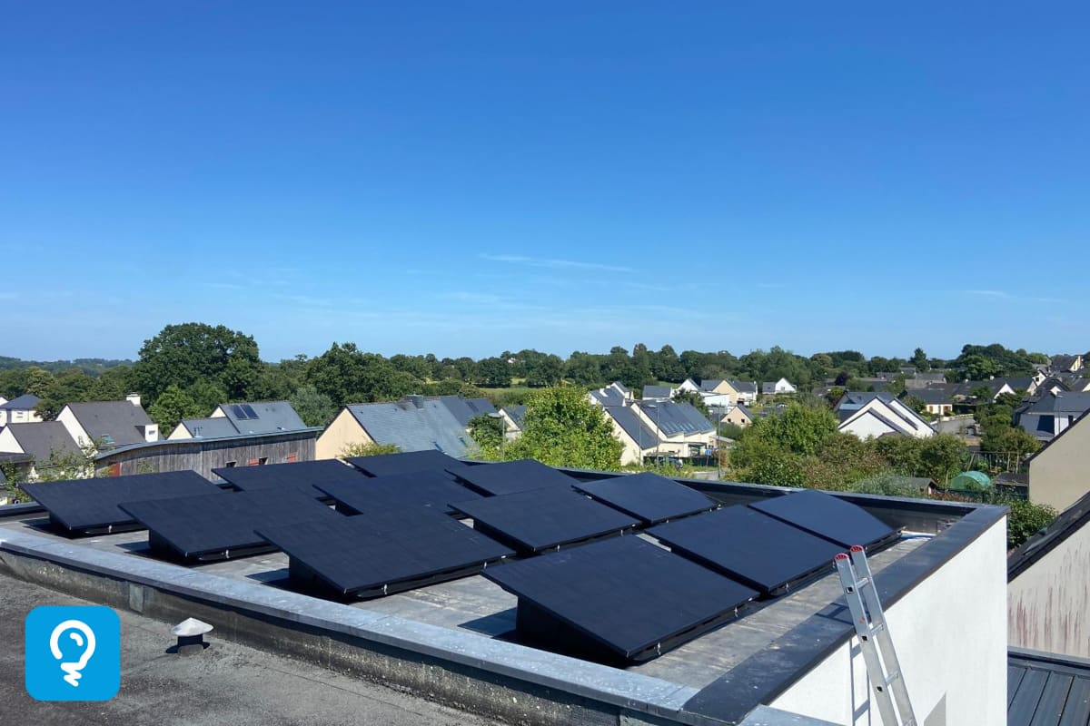 Panneaux photovoltaïques noirs sur un toit plat sous un ciel bleu